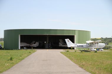 Rundhalle auf dem Flugplatz Grasberg mit einer Cessna davor